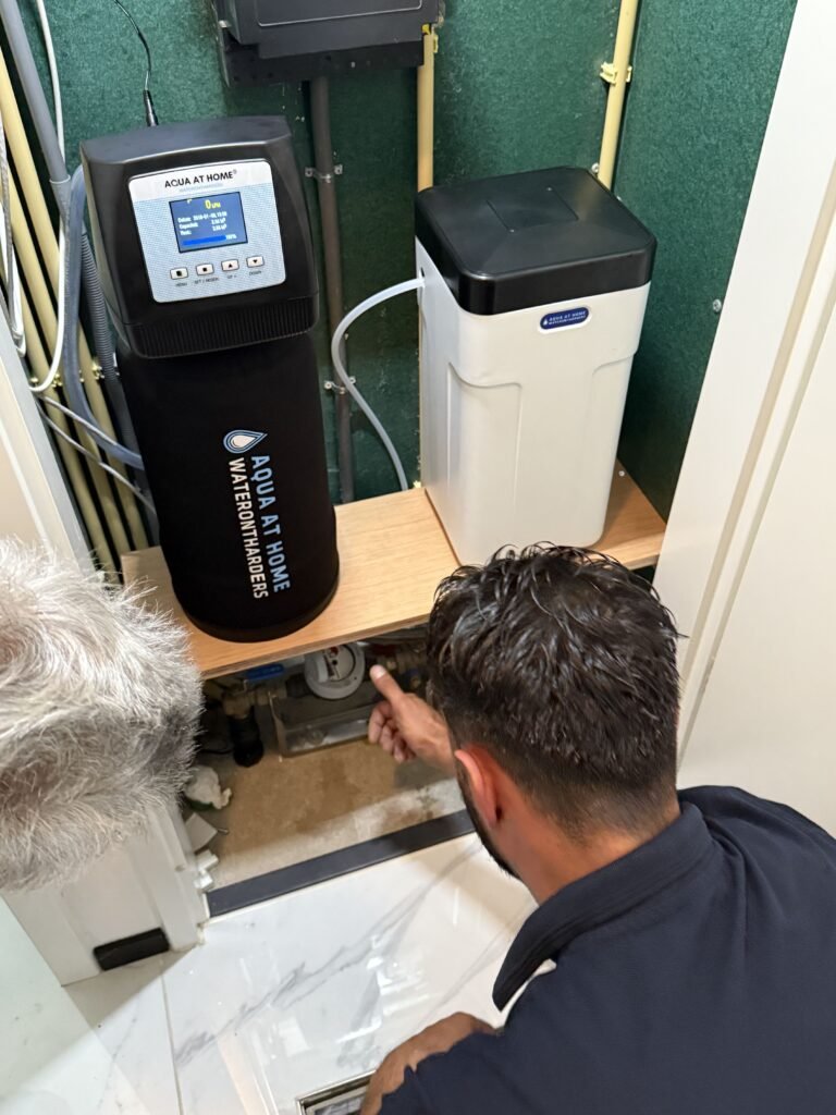Monteur van Aqua at Home voert onderhoud uit aan een waterontharder
